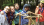 Jeunes filles devant une construction faite de bouts de bois et de cordages, avec une forêt à l'arrière.