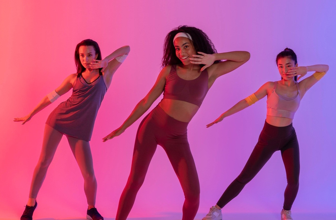 Adolescents s'amusant à danser sur la pelouse verte dans le parc le jour d'été.
