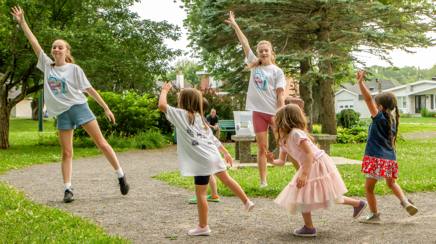 Adolescents s'amusant à danser sur la pelouse verte dans le parc le jour d'été.
